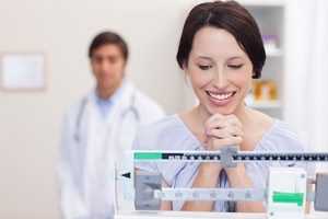 woman standing on scale at doctor's office