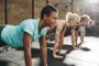 Exercise class smiling doing planks on mats to improve heart health